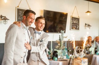 Hochzeitspaar betrachtet festlich geschmückte Hochzeitstorte mit Wunderkerzen in Emden.