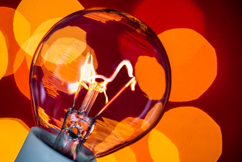 Foto einer Glühbirne als Symbol für gute Ideen vor einem warmen Bokeh-Hintergrund.